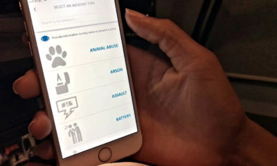 Woman holding phone with Safewatch App, displaying features