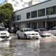 cars in miami drive over sea water that's flooded into streets