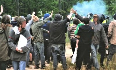 police stop a crowd of people with tear gas