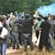 police stop a crowd of people with tear gas