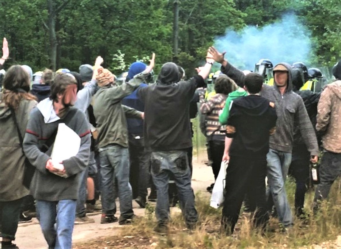 police stop a crowd of people with tear gas